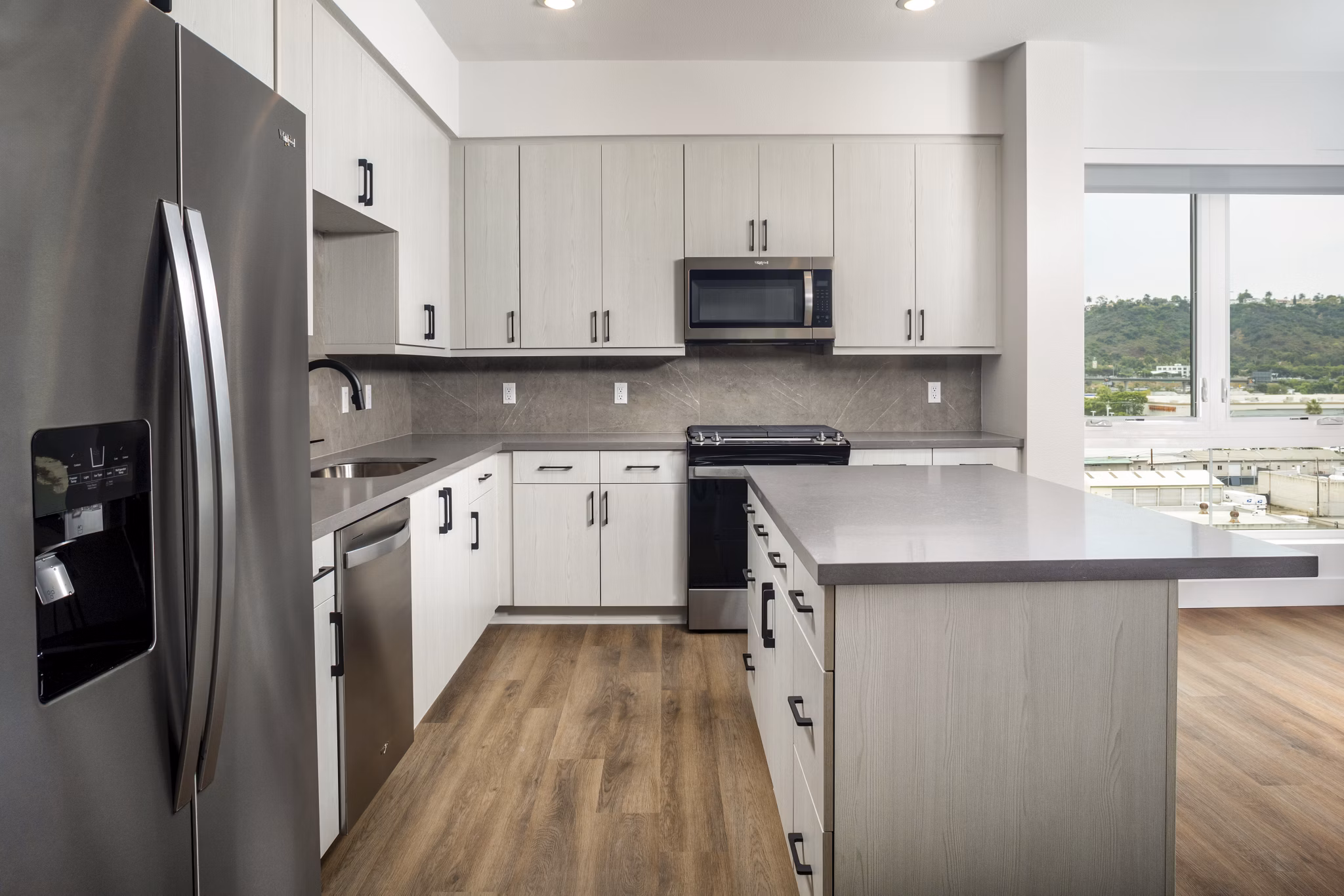Modern kitchen with sleek countertops and stainless steel appliances in Vora Lux Apartments