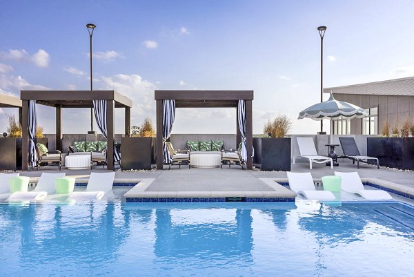 Luxurious pool at Broadstone 2Thirty Apartments, offering a serene retreat with poolside lounge chairs and lush landscaping