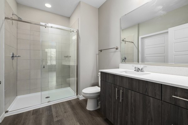 Bathroom with modern fixtures and tile design at Everly on 401 Apartments