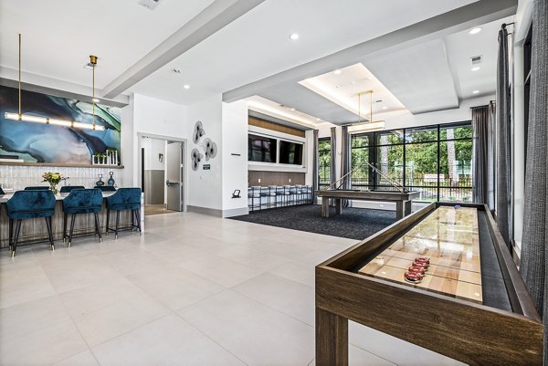 Clubhouse game room with pool table and lounge seating at Everly on 401 Apartments