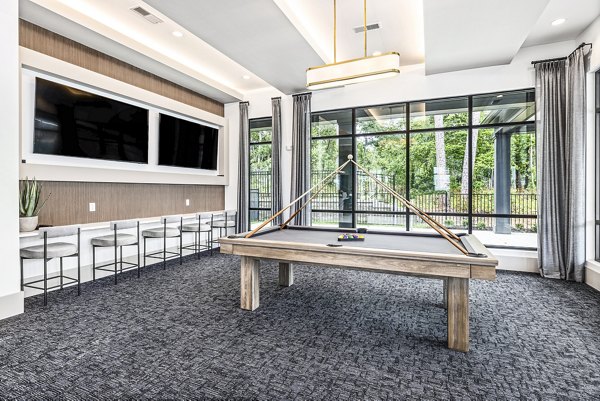 Clubhouse game room featuring billiards and seating at Everly on 401 Apartments