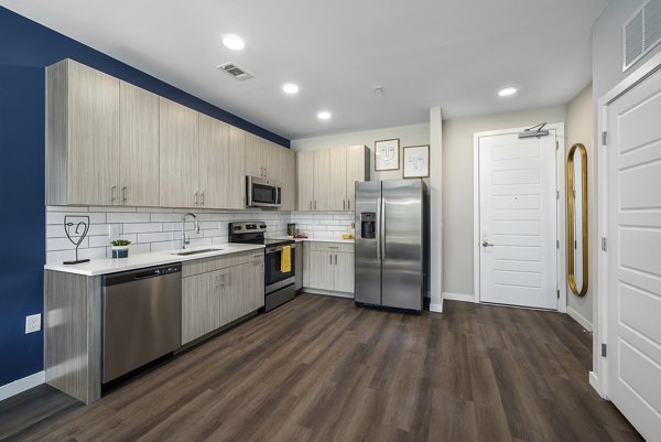 Modern kitchen with stainless steel appliances at Everly on 401 Apartments