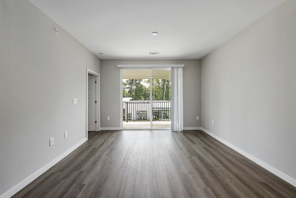 Spacious living room with modern decor and abundant natural light at Everly on 401 Apartments