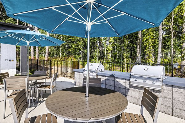 Grill area with modern patio furniture at Everly on 401 Apartments, a luxury outdoor space for residents' relaxation and social gatherings