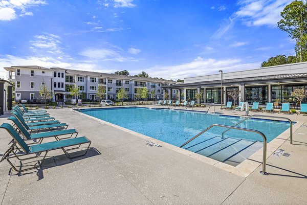 Resort-style pool at Everly on 401 Apartments featuring elegant lounge areas and lush landscaping