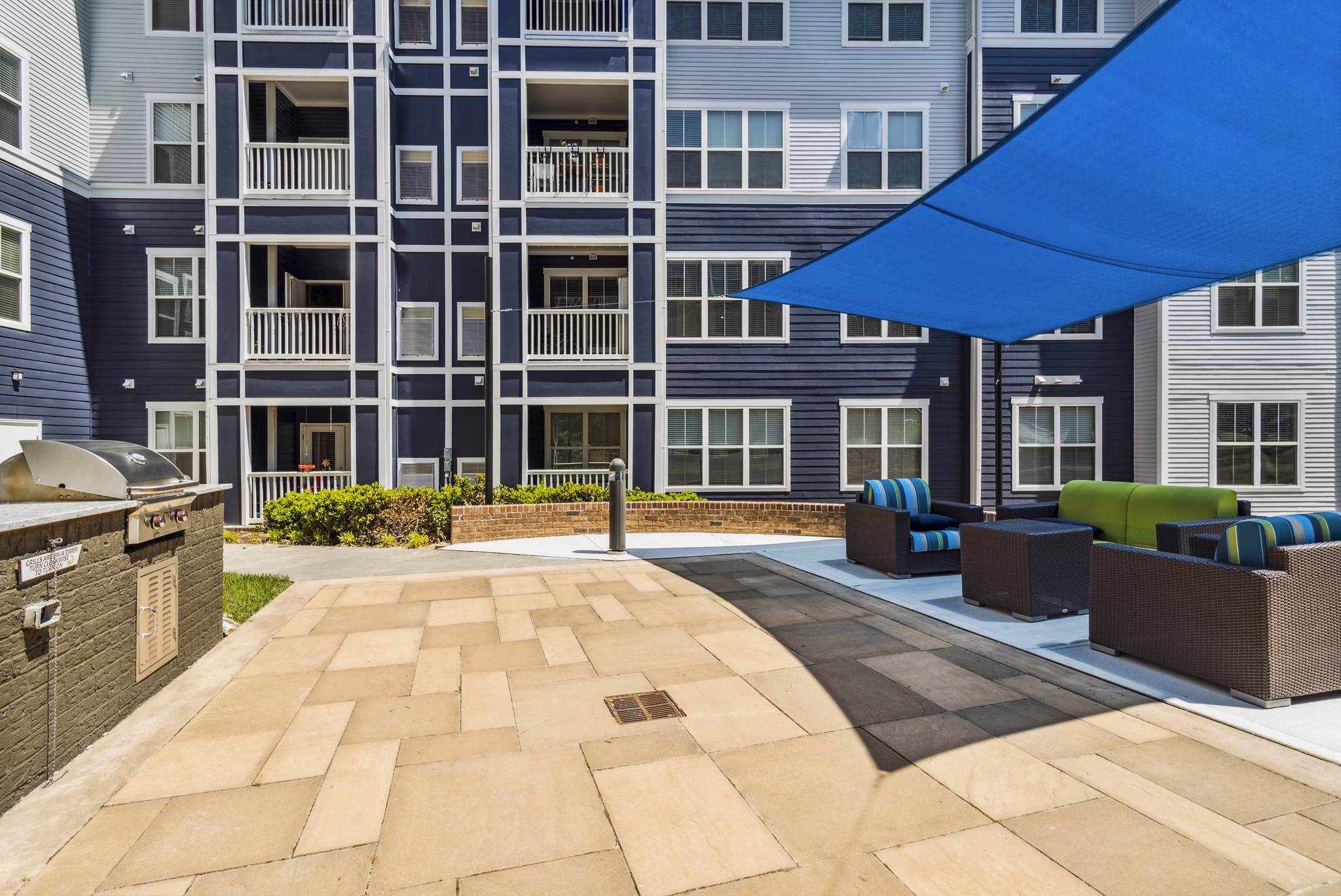 Grill area with modern patio furniture at Level at 401 Apartments, a Greystar luxury property