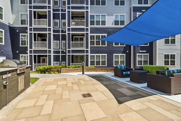 Grill area with modern patio furniture at Level at 401 Apartments, a Greystar luxury property
