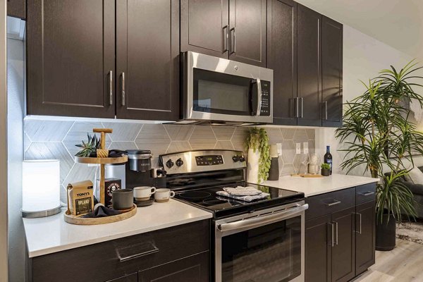 Modern kitchen with granite countertops and stainless steel appliances in Slate Scottsdale Apartments