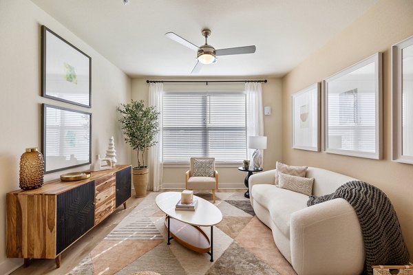 Living room with contemporary furniture and large windows at Birchway Perry Road Apartments, offering luxury living spaces