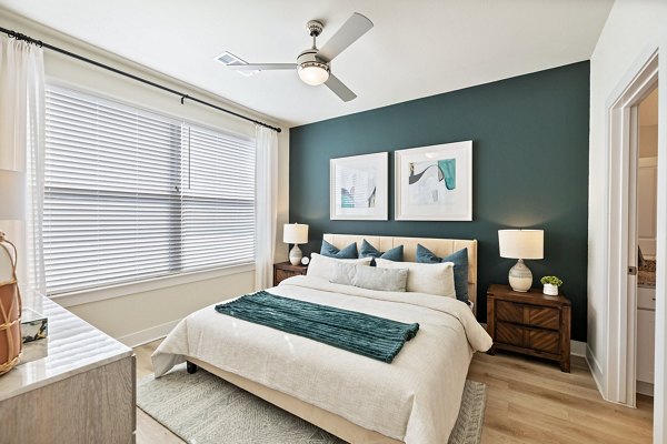 Spacious bedroom with modern decor at Birchway Perry Road Apartments, featuring plush bedding and natural light for luxury living