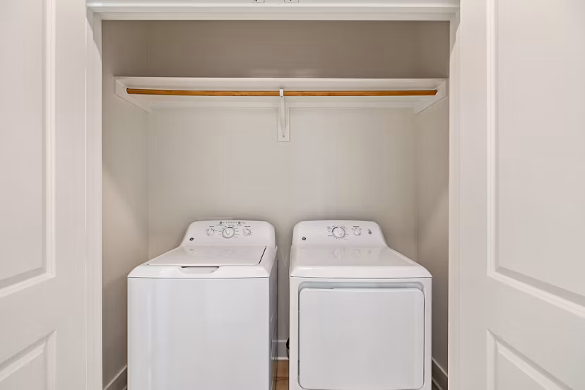 Laundry room featuring modern washers and dryers at Birchway Perry Road Apartments