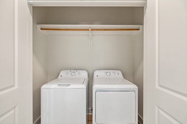 Laundry room featuring modern washers and dryers at Birchway Perry Road Apartments