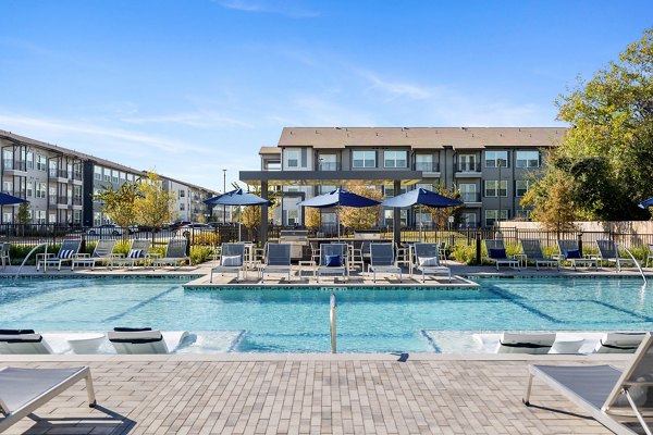 Luxurious pool with lounge chairs at Birchway Perry Road Apartments
