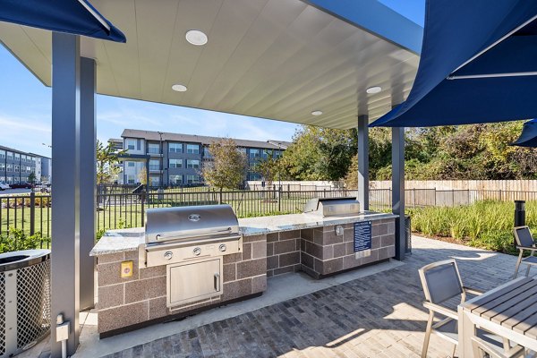 Outdoor grill area with modern seating at Birchway Perry Road Apartments