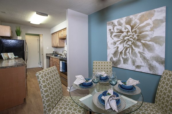 Dining room featuring elegant furnishings and large windows at Collins Crossing Apartments, a luxury property by Greystar