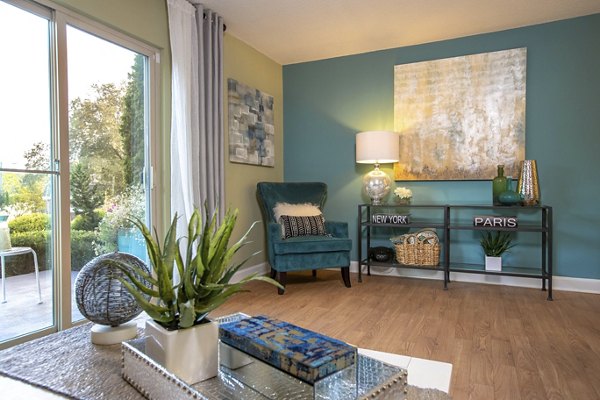 Open-concept living room with large windows at Collins Crossing Apartments
