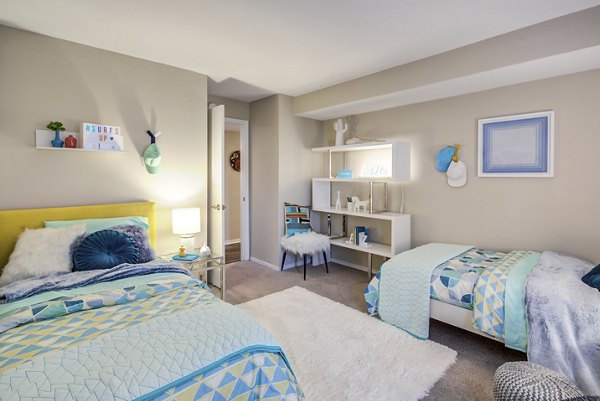 Cozy bedroom with modern decor and ample natural light at Fusion Apartments