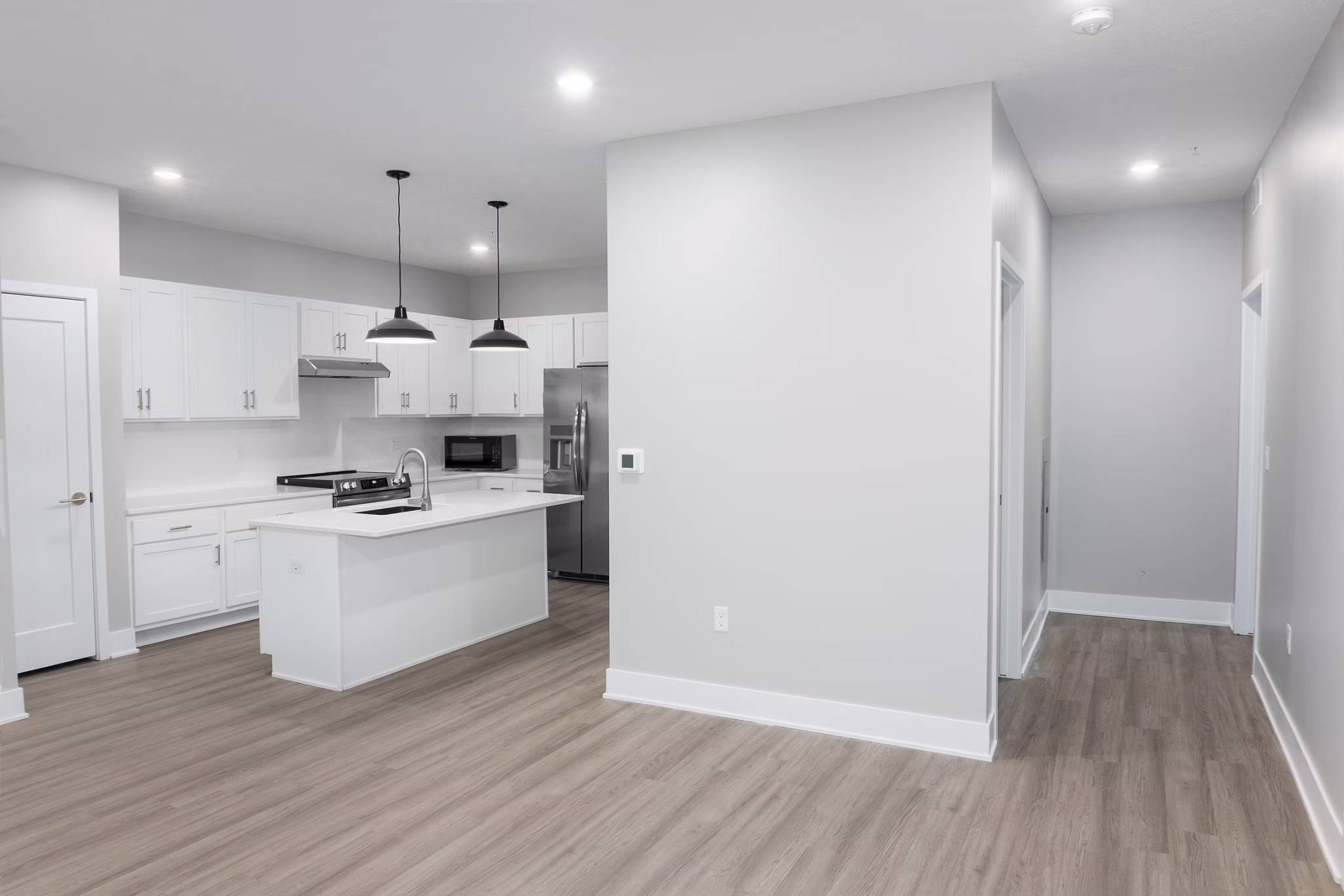 Modern kitchen with island and stainless steel appliances in Allora 168 Apartments, luxury living space in a desirable urban location