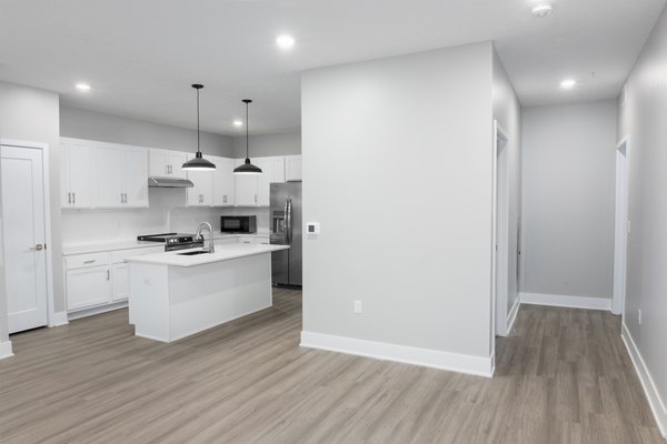 Modern kitchen with island and stainless steel appliances in Allora 168 Apartments, luxury living space in a desirable urban location