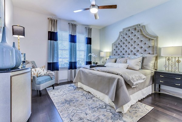 Cozy bedroom with modern furnishings at The Laurel Preston Hollow Apartments