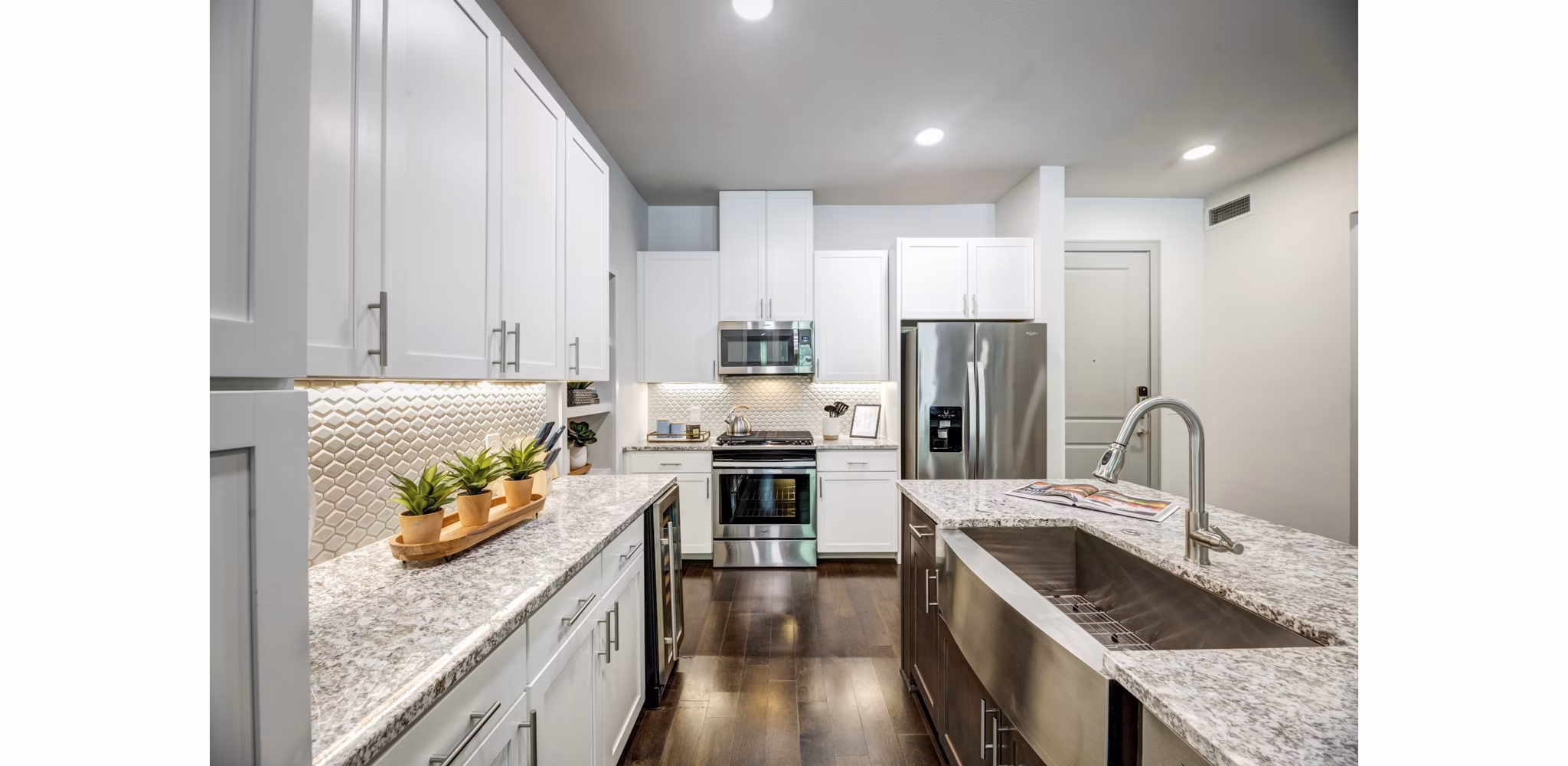 Modern kitchen featuring stainless steel appliances and granite countertops in The Laurel Preston Hollow Apartments