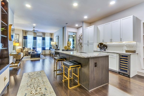 Modern kitchen featuring stainless steel appliances and granite countertops in The Laurel Preston Hollow Apartments