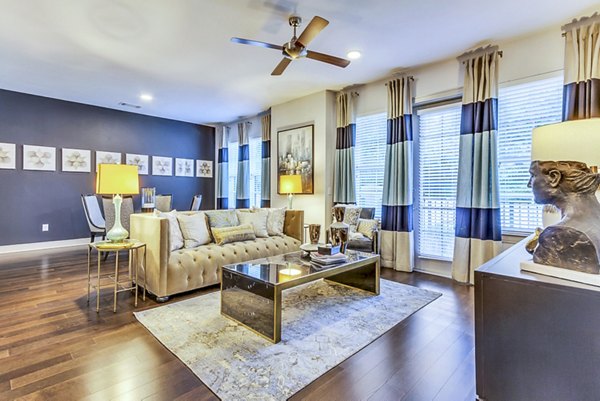 Elegant living room with modern decor at The Laurel Preston Hollow Apartments, featuring cozy seating and large windows for ample natural light