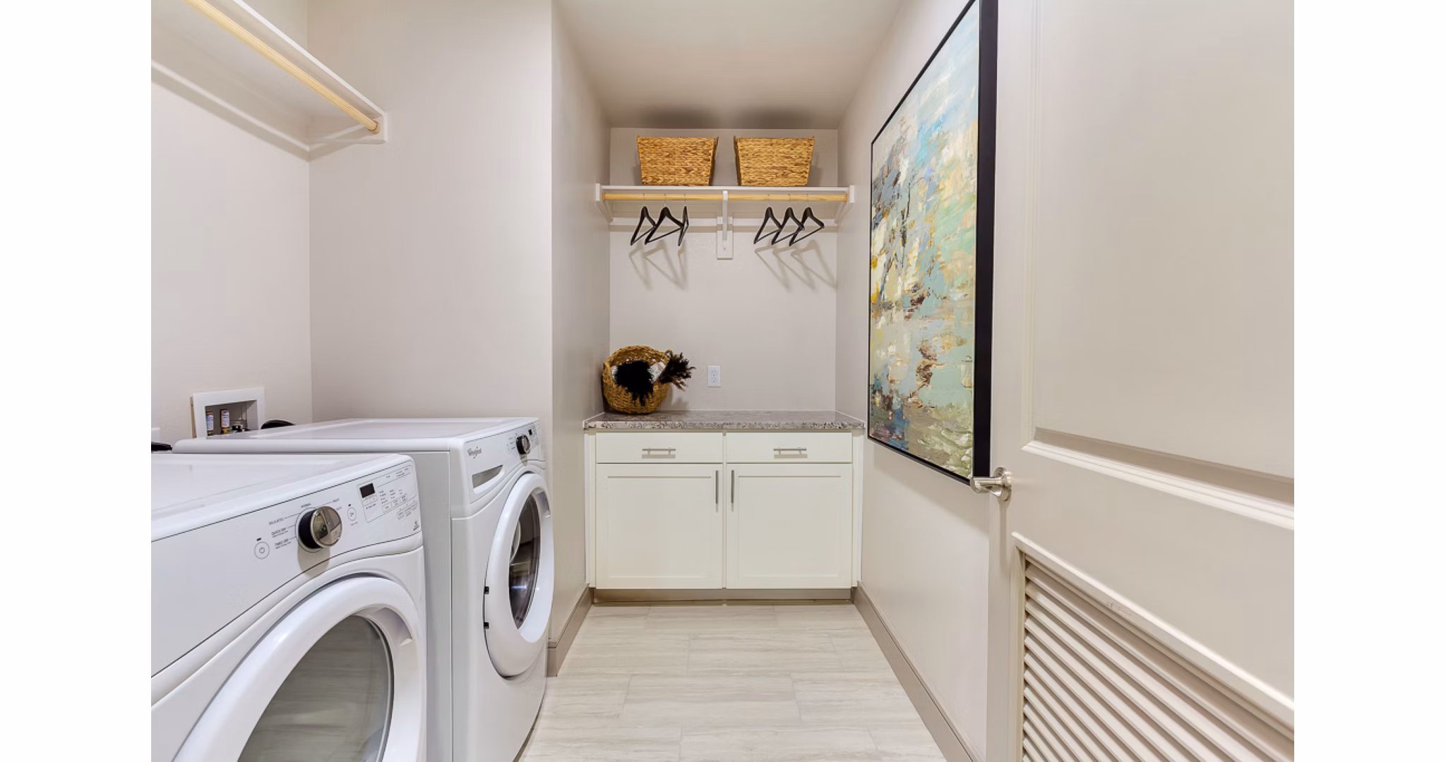 Modern laundry room with high-efficiency washers and dryers at The Laurel Preston Hollow Apartments