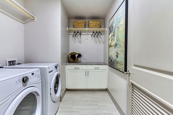 Modern laundry room with high-efficiency washers and dryers at The Laurel Preston Hollow Apartments