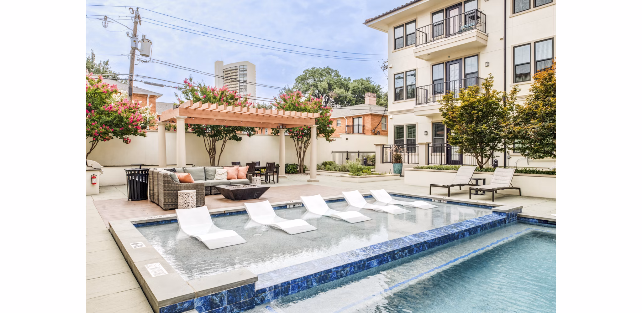 Resort-style pool surrounded by lush landscaping at The Laurel Preston Hollow Apartments offering luxury living amenities