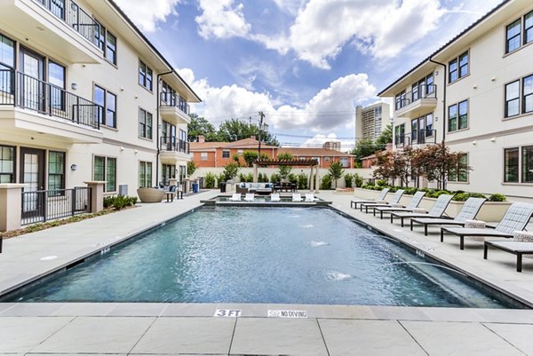 Resort-style pool surrounded by lush landscaping at The Laurel Preston Hollow Apartments offering luxury living amenities