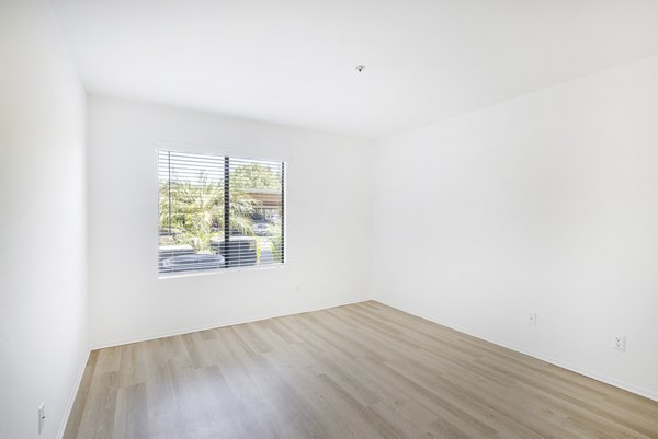 Elegant bedroom with modern decor at The Landing Apartments featuring plush bedding and ambient lighting