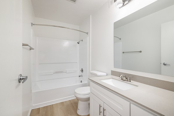 Bathroom featuring modern fixtures and marble countertop at The Landing Apartments