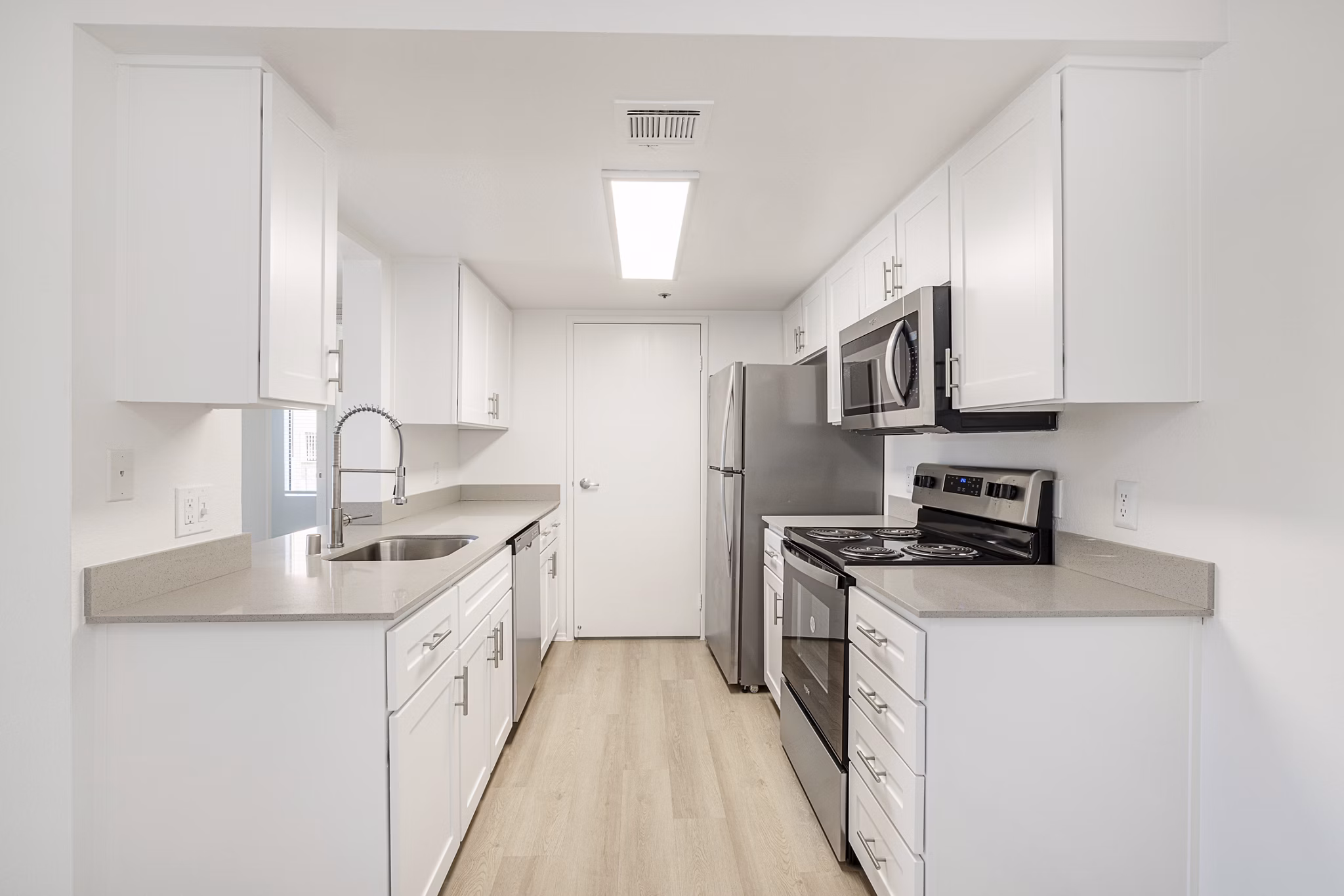 Modern kitchen with sleek countertops and stainless steel appliances at The Landing Apartments, a Greystar community