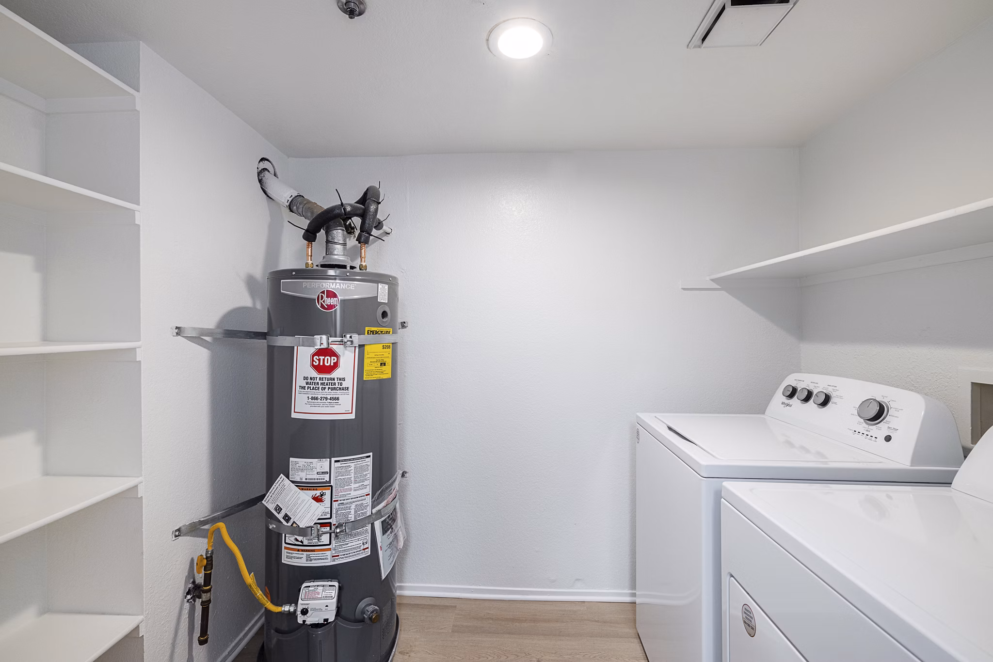Laundry room with modern appliances at The Landing Apartments featuring ample storage and folding space