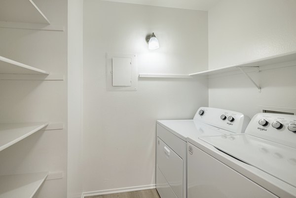 Laundry room with modern appliances at The Landing Apartments, a Greystar community