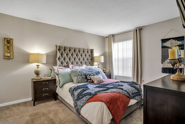 Cozy bedroom with elegant decor and ample natural light at Castilian Apartments