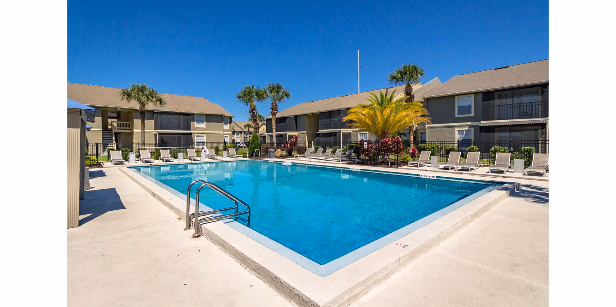 Inviting pool area at Castilian Apartments with lounge seating and landscaped surroundings, perfect for relaxation and sunny days