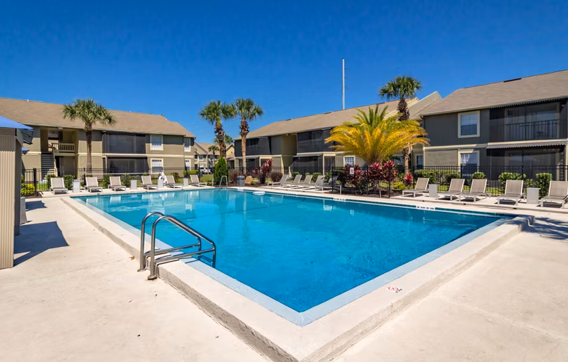 Inviting pool area at Castilian Apartments with lounge seating and landscaped surroundings, perfect for relaxation and sunny days