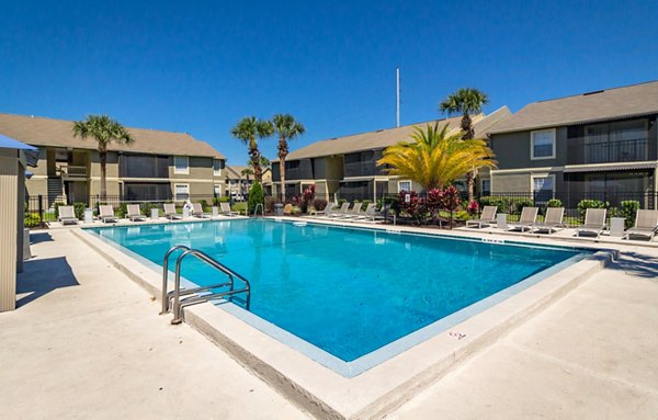 Inviting pool area at Castilian Apartments with lounge seating and landscaped surroundings, perfect for relaxation and sunny days