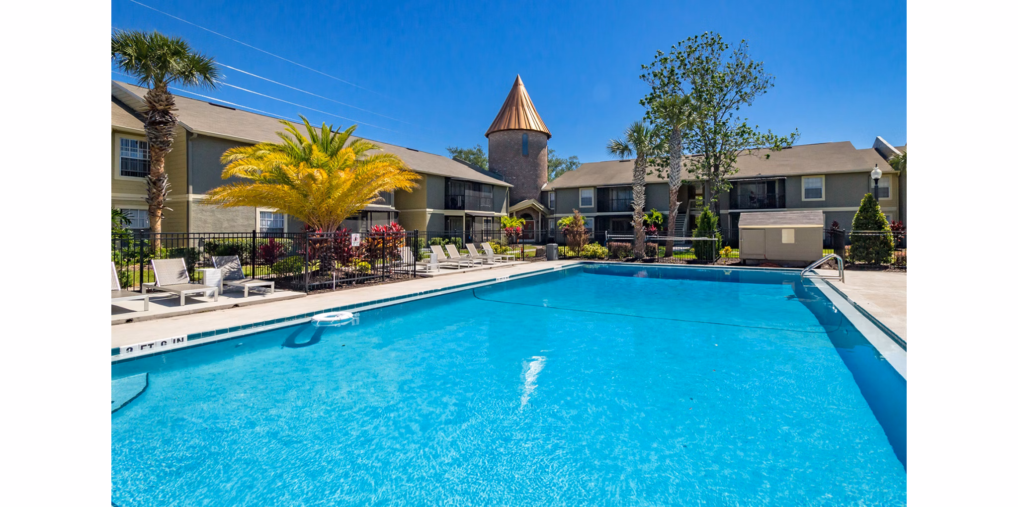 Infinity pool with lush landscaping at Castilian Apartments, offering luxurious relaxation and cityscape views