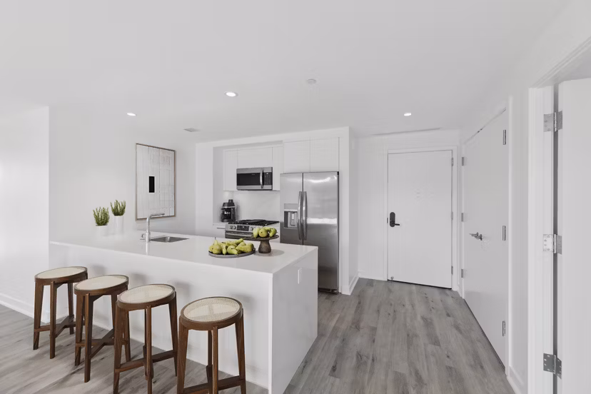Modern kitchen with stainless steel appliances and marble countertops at Crossing DC Apartments