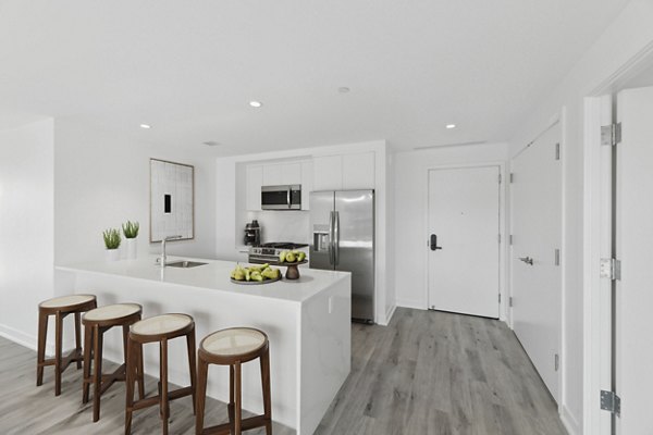 Modern kitchen with stainless steel appliances and marble countertops at Crossing DC Apartments