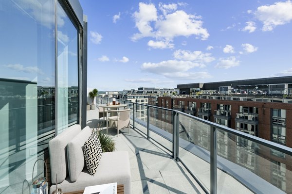 Charming outdoor patio with modern furniture at Crossing DC Apartments, ideal for relaxation and social gatherings