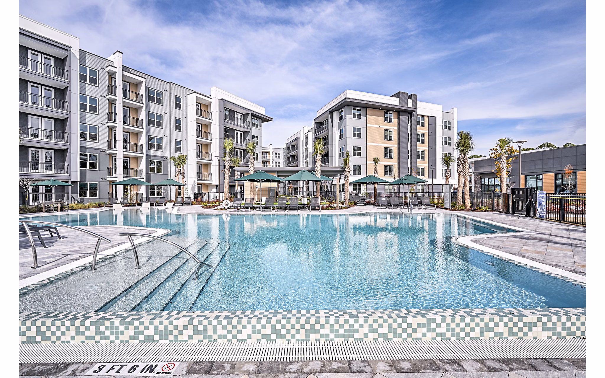 Resort-style pool surrounded by lush landscaping at Presidium Park Apartments