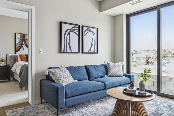 Modern living room with sleek furnishings and large windows at The Eddi Apartments