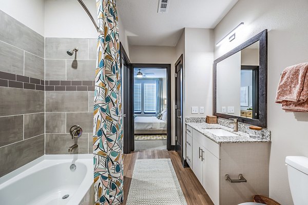 Luxury bathroom with marble countertops and glass shower in Presidium Regal Apartments