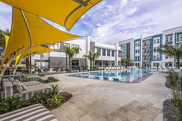 Resort-style pool at Presidium Regal Apartments with sun loungers and lush landscaping, offering a luxurious outdoor retreat for residents