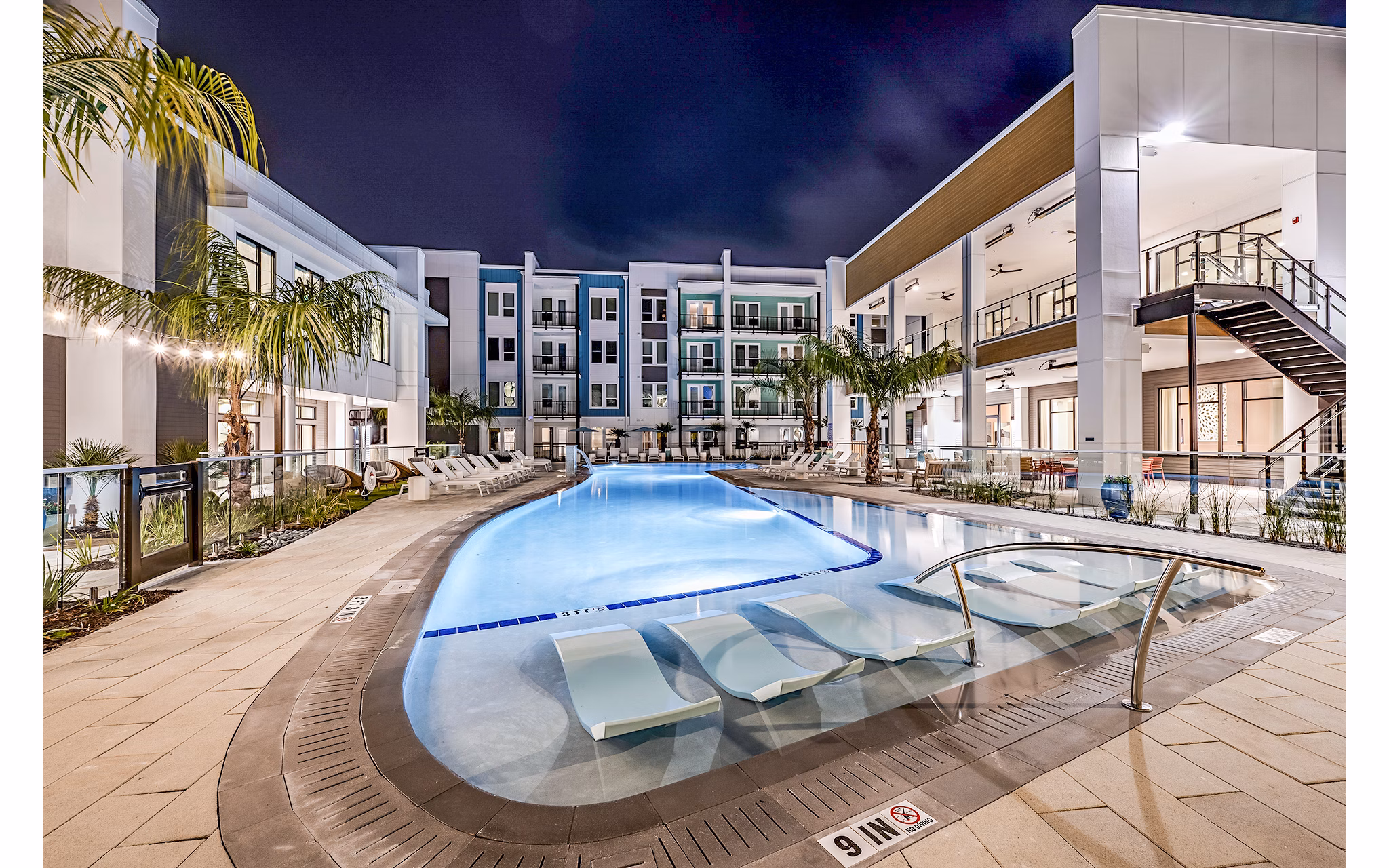 Luxury pool at Presidium Regal Apartments offering serene lounging experience with modern design and lush landscaping