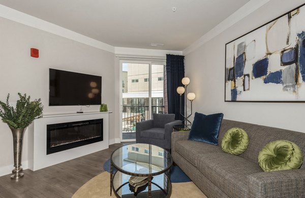 Living room with modern decor and large windows at The Westlyn Apartments